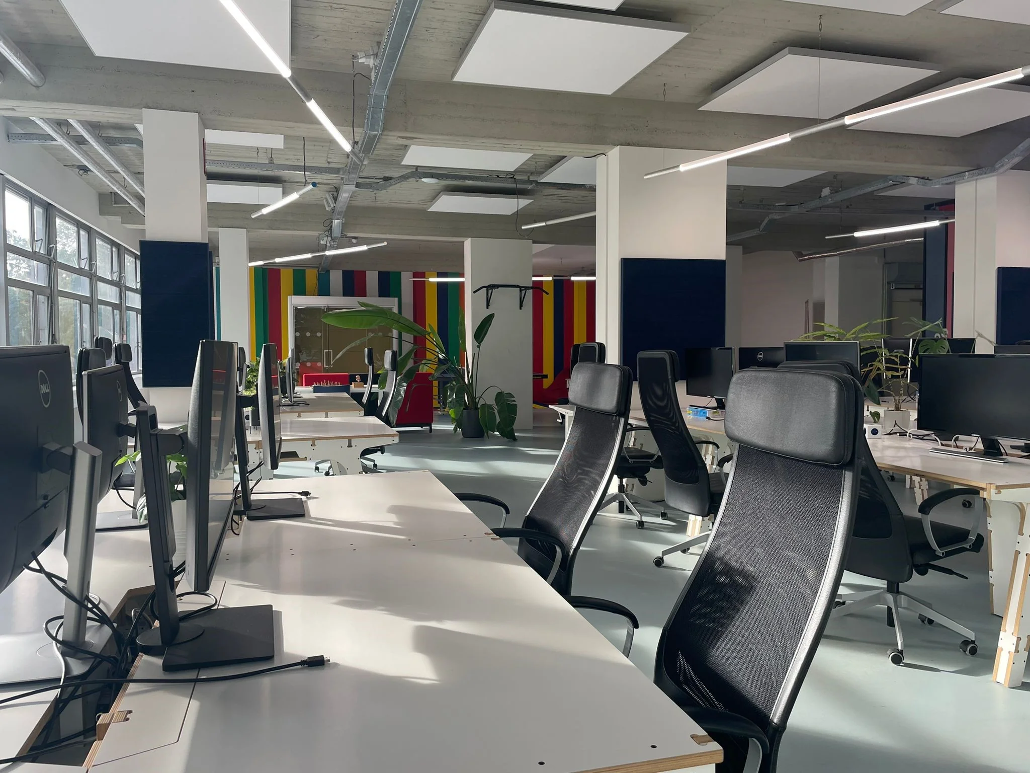 Moderne en ruime kantoortuin aan de Van Leijenberghlaan met werkplekken, ergonomische stoelen en kleurrijke wandpanelen.